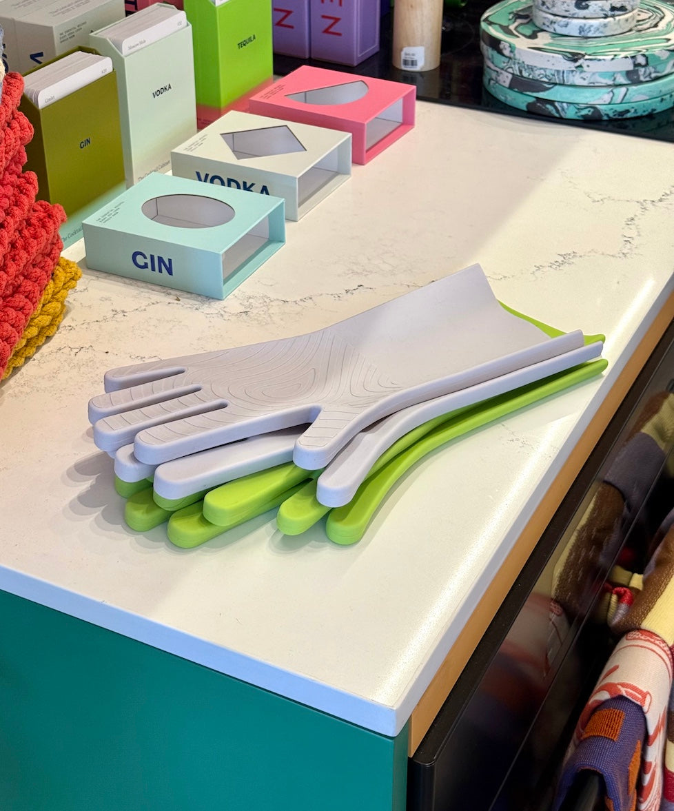 Set of colorful kitchen gloves on a countertop with various items in the background