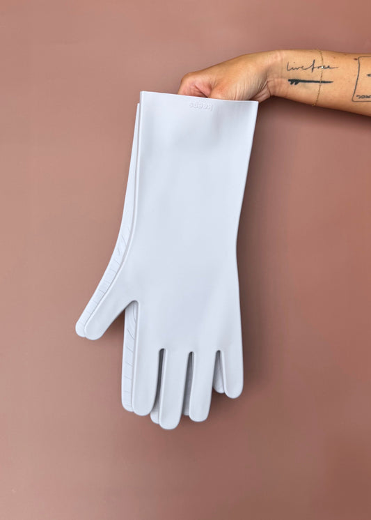 keeps gloves in the moondust colorway held up with bare hands against a terracotta color backdrop